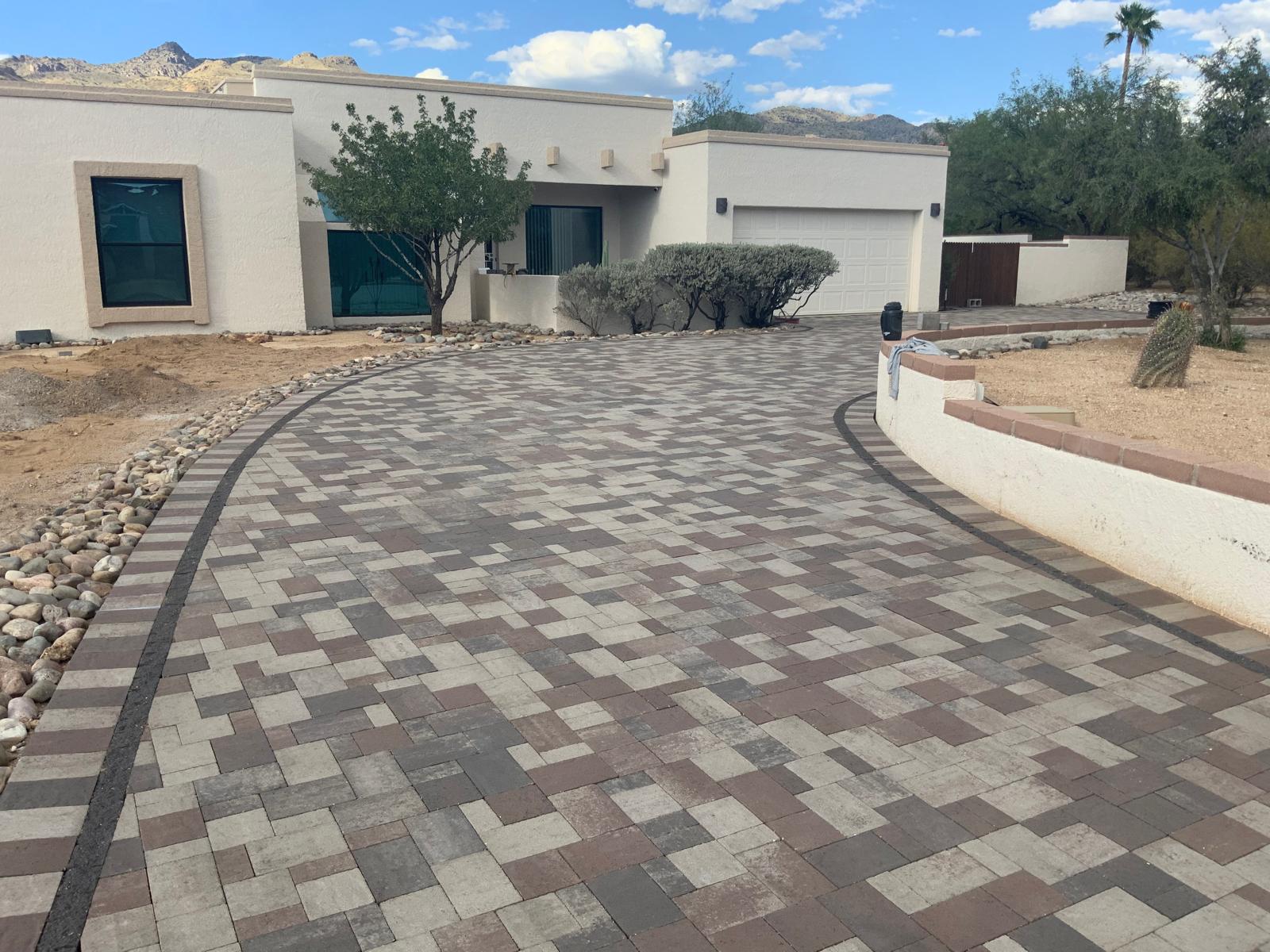Multi-tone paver driveway with dark border and decorative pattern in Phoenix Arizona